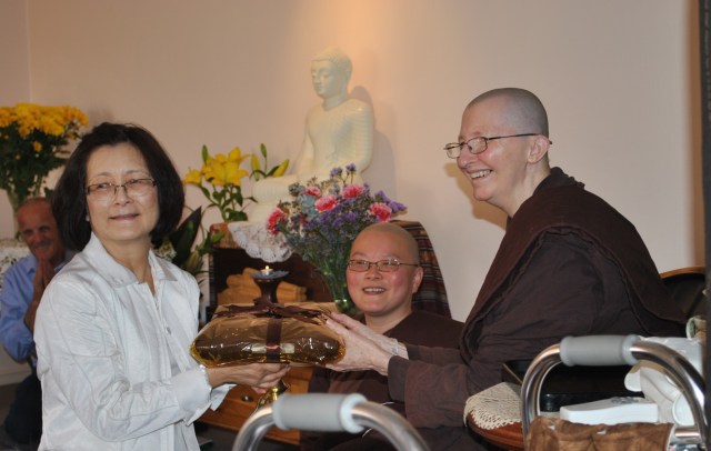 Peggy Chan offering the robe material to the bhikkhunis at Patacara Bhikkhuni Hermitage during the End of Rains Cloth Offering Ceremony 2013. Photo by Havindra.